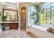 Bright bathroom showcasing a soaking tub, a glass shower, and a large pane window bringing natural light at 3704 Wilkins Cir, Powder Springs, GA 30127