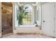 A bright bathroom with a large window, soaking tub, glass shower, light tile and white door at 3704 Wilkins Cir, Powder Springs, GA 30127
