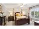 Spacious bedroom with a four-poster bed, floral wallpaper, and natural light from the windows at 3704 Wilkins Cir, Powder Springs, GA 30127