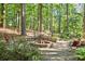 Secluded backyard fire pit with stone patio surrounded by mature trees, perfect for outdoor entertaining at 3704 Wilkins Cir, Powder Springs, GA 30127