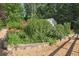 Beautiful backyard garden with colorful flowers and greenery, bordered by a stone wall and gravel path at 3704 Wilkins Cir, Powder Springs, GA 30127