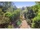 A beautiful gravel path surrounded by flowers and greenery leading to a tranquil wooded landscape at 3704 Wilkins Cir, Powder Springs, GA 30127
