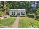 Charming backyard greenhouse featuring large windows, a quaint walkway, and beautiful surrounding landscaping at 3704 Wilkins Cir, Powder Springs, GA 30127