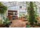 The bright greenhouse with shelving, plants, and potting benches for a gardener's paradise at 3704 Wilkins Cir, Powder Springs, GA 30127
