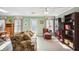 Cozy living room with vintage floral sofa, shelving, and natural light from nearby windows at 3704 Wilkins Cir, Powder Springs, GA 30127