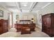This primary bedroom features a tray ceiling and ample space with refined wood furniture and decor at 3704 Wilkins Cir, Powder Springs, GA 30127