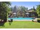 Lush backyard with a sparkling pool and pergola covered lounge area for relaxation and entertaining at 3704 Wilkins Cir, Powder Springs, GA 30127