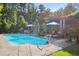 Sparkling pool with lounge area, lush landscaping, and outdoor entertaining space at 3704 Wilkins Cir, Powder Springs, GA 30127