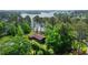 Stunning aerial view of a beautiful lake house surrounded by mature trees, with lush landscaping at 3865 Adams Rd, Cumming, GA 30041