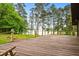 Large wooden deck with a scenic view of the lake, surrounded by rope railing and greenery at 3865 Adams Rd, Cumming, GA 30041