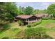 Spacious lake house with a back deck surrounded by lush greenery and well-manicured lawn at 3865 Adams Rd, Cumming, GA 30041