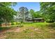 Spacious backyard with lush greenery, mature trees, and a charming deck for outdoor living at 3865 Adams Rd, Cumming, GA 30041