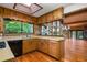 Well-lit kitchen with wooden cabinetry, a skylight, and a view of the living area and lake beyond at 3865 Adams Rd, Cumming, GA 30041