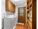 Functional laundry room with washer, dryer, storage cabinets, and outdoor access at 3865 Adams Rd, Cumming, GA 30041