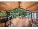 Bright living room with floor to ceiling windows, hardwood floors, and an adjacent bar area overlooking the lake at 3865 Adams Rd, Cumming, GA 30041