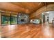 Spacious living room with hardwood floors, wood ceilings, a stone fireplace, and abundant natural light at 3865 Adams Rd, Cumming, GA 30041