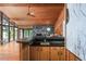 Open living room with wood ceilings, stone fireplace, and floor-to-ceiling windows overlooking the lake at 3865 Adams Rd, Cumming, GA 30041