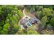 Stunning aerial of a large home featuring a pool, long driveway, and surrounded by beautiful, mature trees at 7305 Breeze Bay Rd, Cumming, GA 30041