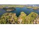 Beautiful aerial view of a lake house surrounded by lush trees and glistening lake waters at 7305 Breeze Bay Rd, Cumming, GA 30041