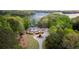 Stunning aerial view of lakefront home with lush landscaping, circular driveway, and breathtaking lake views at 7305 Breeze Bay Rd, Cumming, GA 30041