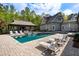 Charming home showcasing a backyard with a pool, a pool house, outdoor furniture, and mature trees at 7305 Breeze Bay Rd, Cumming, GA 30041