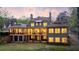 A beautiful house with an outdoor living space, featuring a covered patio, well-manicured lawn, and trees at 7305 Breeze Bay Rd, Cumming, GA 30041