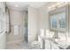 Bright bathroom with a glass shower, vanity with framed mirror, and marble flooring, offering a clean and modern space at 7305 Breeze Bay Rd, Cumming, GA 30041