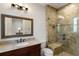 Stylish bathroom features a glass shower and granite countertop with dark wood cabinets at 7305 Breeze Bay Rd, Cumming, GA 30041
