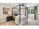 Bedroom featuring a four-poster bed, neutral décor, large windows, and carpeted flooring, creating a serene retreat at 7305 Breeze Bay Rd, Cumming, GA 30041