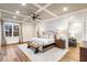 Bright primary bedroom features hardwood floors, a ceiling fan, recessed lighting, and large windows offering ample natural light at 7305 Breeze Bay Rd, Cumming, GA 30041