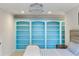 Bedroom with custom built-in blue bookshelves and stylish chandelier at 7305 Breeze Bay Rd, Cumming, GA 30041