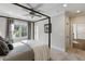 Bedroom featuring a four-poster bed, neutral décor, large windows, and carpeted flooring, creating a serene retreat at 7305 Breeze Bay Rd, Cumming, GA 30041