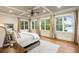 Bright primary bedroom features hardwood floors, recessed lighting, a ceiling fan, and large windows offering natural light at 7305 Breeze Bay Rd, Cumming, GA 30041