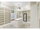 Spacious walk-in closet with custom built-in shelving, center island, and full-length mirror for ample storage at 7305 Breeze Bay Rd, Cumming, GA 30041