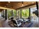 Inviting covered patio featuring wood ceiling, ceiling fans, fireplace, and comfortable seating with lake views at 7305 Breeze Bay Rd, Cumming, GA 30041