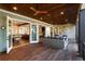 Inviting covered porch with wood floors, comfortable seating, and views into the living area through glass doors at 7305 Breeze Bay Rd, Cumming, GA 30041