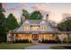 Charming home with a manicured front lawn, mature landscaping, and a welcoming facade with a covered entry at 7305 Breeze Bay Rd, Cumming, GA 30041
