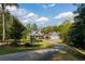 Aerial view of a gorgeous property with expansive lawn and circular driveway nestled among mature trees at 7305 Breeze Bay Rd, Cumming, GA 30041