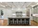 Spacious kitchen features an island with seating, modern appliances and stylish pendant lighting at 7305 Breeze Bay Rd, Cumming, GA 30041
