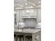 Close up on a kitchen island with stone countertops, a gas range, and stylish cabinetry at 7305 Breeze Bay Rd, Cumming, GA 30041