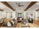 Expansive living area with hardwood floors, a large sectional sofa, stairs, and natural light throughout the space at 7305 Breeze Bay Rd, Cumming, GA 30041