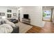 Charming living room featuring hardwood floors, shiplap accent wall, a cozy sofa, and large bright windows at 7305 Breeze Bay Rd, Cumming, GA 30041