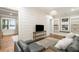Beautiful living room with hardwood floors, shiplap accent wall, built-in bookcases, and a large window with a view at 7305 Breeze Bay Rd, Cumming, GA 30041