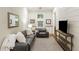 Comfortable living room with a plush sofa, accent chair, TV, and natural light, creating a cozy atmosphere at 7305 Breeze Bay Rd, Cumming, GA 30041