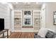 Inviting living area featuring built-in bookcases, a window seat, shiplap accent wall, and hardwood flooring at 7305 Breeze Bay Rd, Cumming, GA 30041