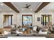 Spacious living room with hardwood floors, wood beams, and multiple seating areas with access to the outside at 7305 Breeze Bay Rd, Cumming, GA 30041
