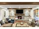 Cozy living room with stone fireplace, built-in cabinets, hardwood floors, and comfortable seating around the fire at 7305 Breeze Bay Rd, Cumming, GA 30041