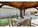 Inviting covered outdoor dining area with a ceiling fan and view of the pool at 7305 Breeze Bay Rd, Cumming, GA 30041