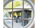 View of the outdoor pavilion through a round window, showcasing inviting seating and decor at 7305 Breeze Bay Rd, Cumming, GA 30041