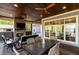 Covered outdoor patio with a fireplace, dining area, and views of the backyard and lake at 7305 Breeze Bay Rd, Cumming, GA 30041